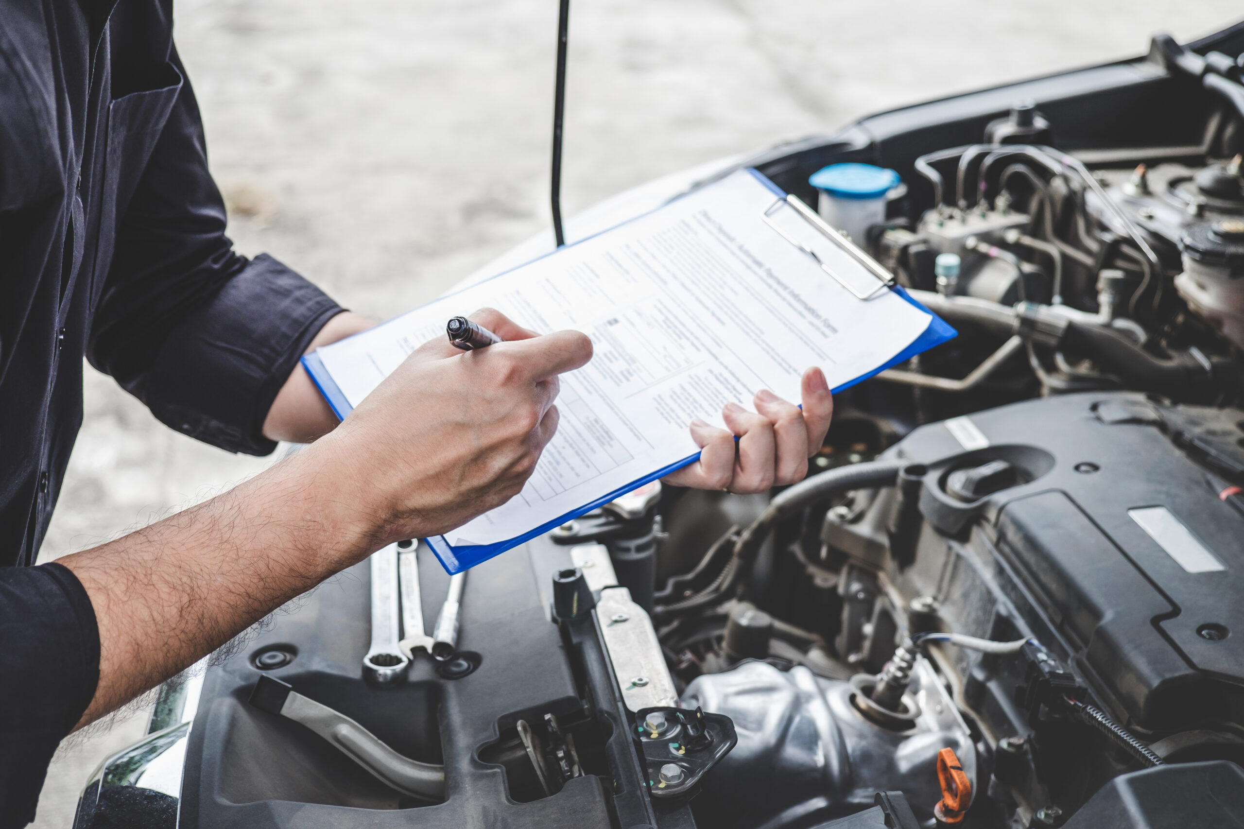 Services car engine machine concept, Automobile mechanic repairm Services car engine machine concept, Automobile mechanic repairman checking a car engine with inspecting writing to the clipboard the checklist for repair machine, car service and maintenance.